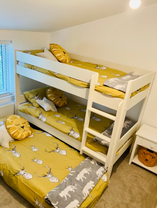 Boyne House, Pembrokeshire 4 White bunk beds with an additional pull-out bed and yellow animal-patterned bedding at Boyne House