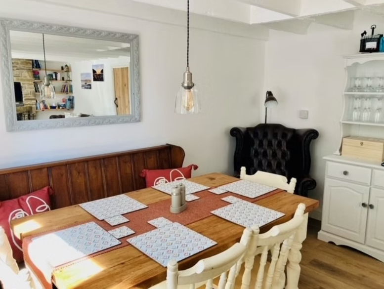 Boyne House, Pembrokeshire 6 Wooden dining table with chairs and bench seating beneath exposed beams at Boyne House