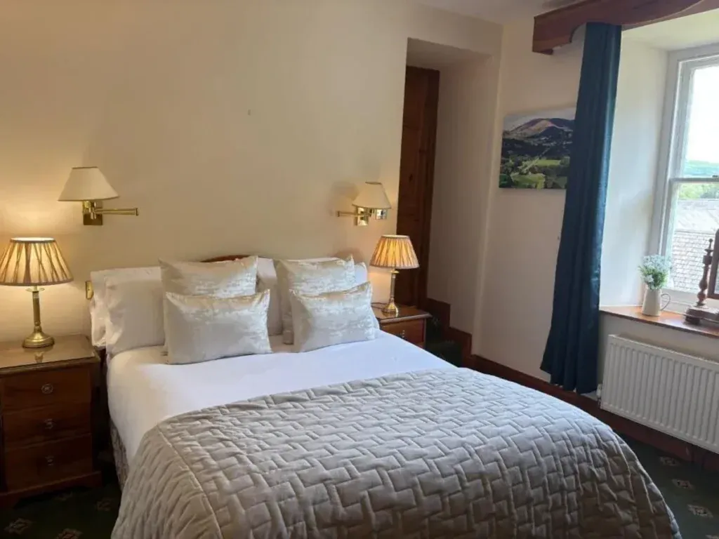 Craig y Nos Castle, Swansea Valley, Powys 1 Double bed with silver bedding, wooden bedside cabinets and lamps beside a window at Craig y Nos Castle