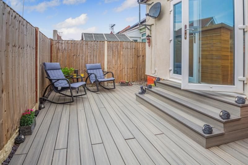 Coastal Bungalow with Decked Garden, Kinmel Bay, North Wales 2 Enclosed decked garden with two rocking chairs and steps up to French doors