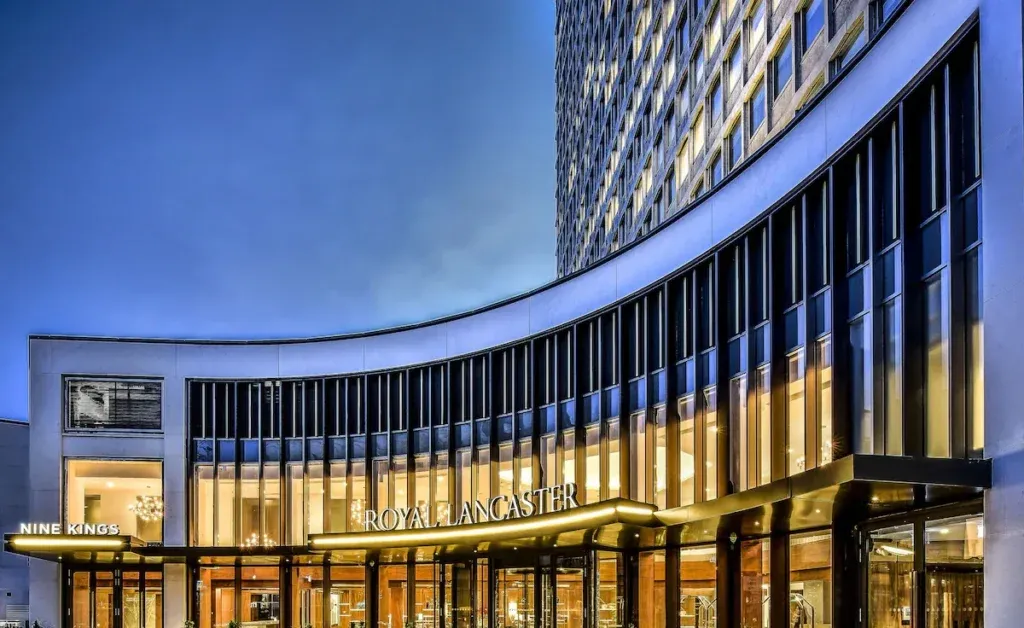 Illuminated Royal Lancaster London hotel exterior with a curved frontage at dusk
