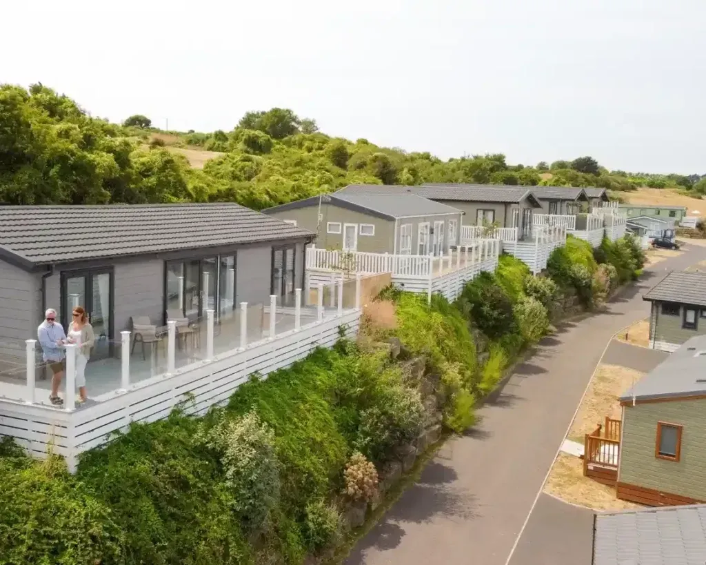 Swanage Coastal Park, Swanage, Dorset 1 Row of holiday lodges with raised decks beside a sloping road at Swanage Coastal Park