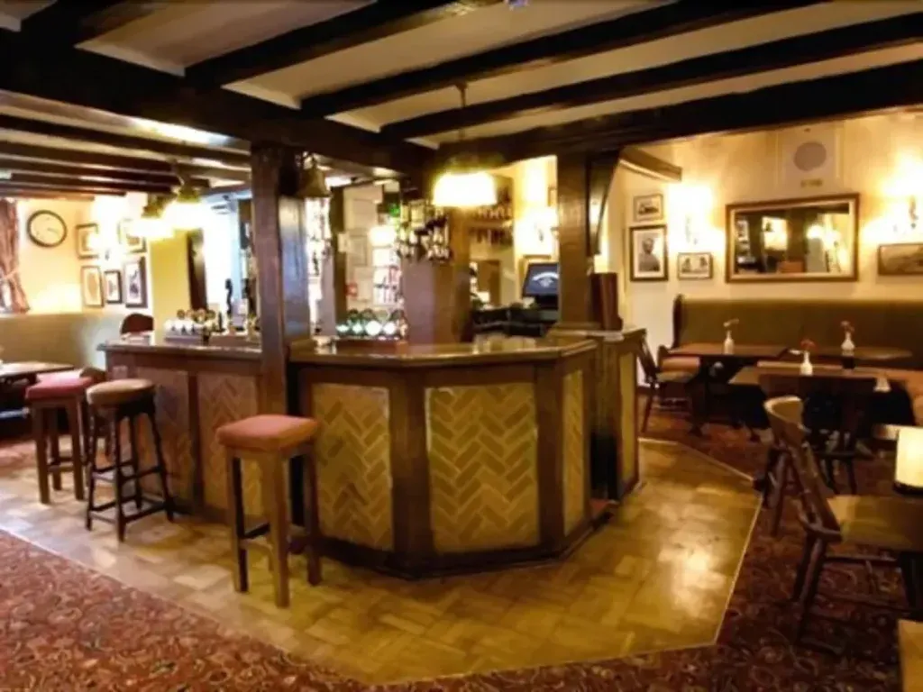 The Talbot, Ledbury, Herefordshire 2 Beamed bar area at The Talbot in Ledbury with a central bar, wooden stools and patterned carpet
